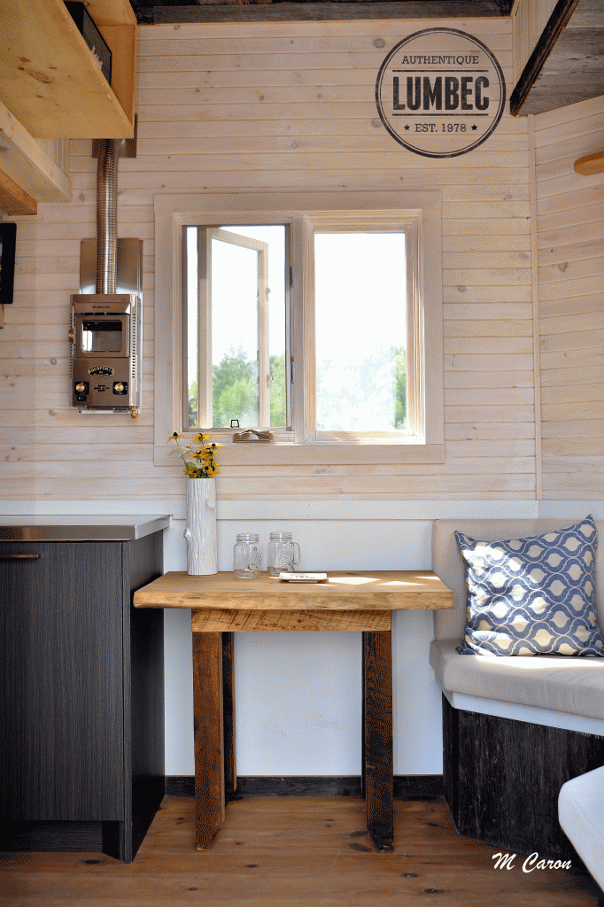En entrant, une fenêtre s'ouvre sur l'extérieur.  La table, construite avec du matériel recyclé se déplace pour permettre à plus de gens partager un bon repas. 
